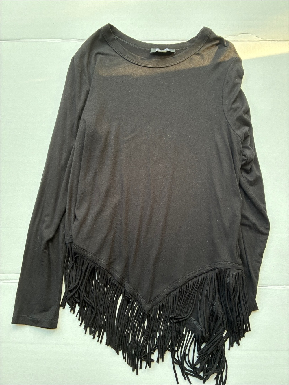 Black long-sleeve top with fringe bottom
